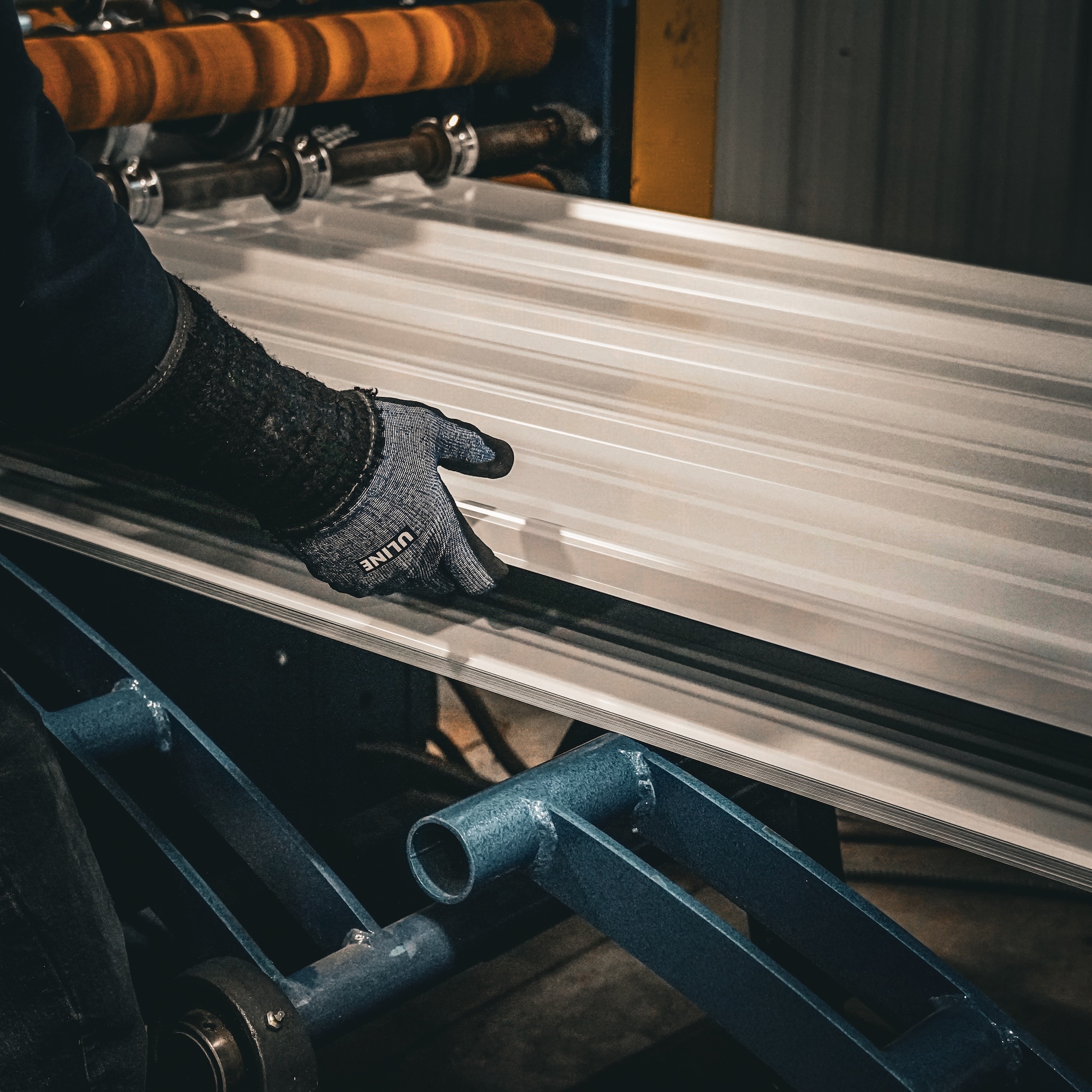 Worker guiding roll formed steel through production equipment